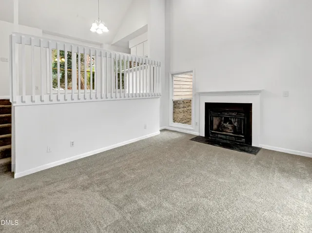 a view of an empty room with a fireplace and a window