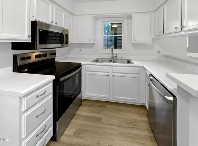 a kitchen with a sink stove and microwave