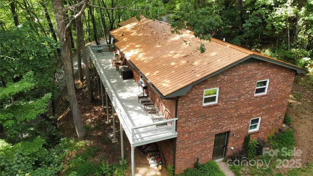 a aerial view of a house with a yard and large trees