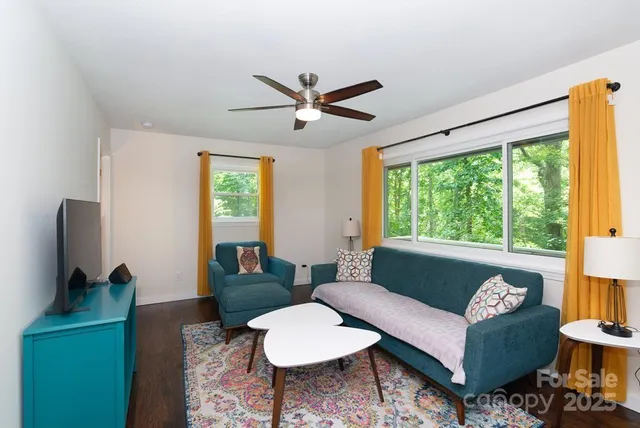 a living room with furniture a flat screen tv and a large window