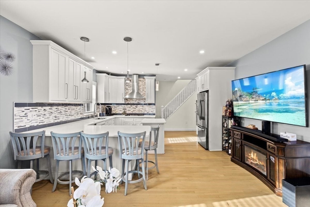 6 Arion Street Boston, MA 02125 - Photo 14 of 42 a large kitchen with stainless steel appliances kitchen island granite countertop a table and chairs