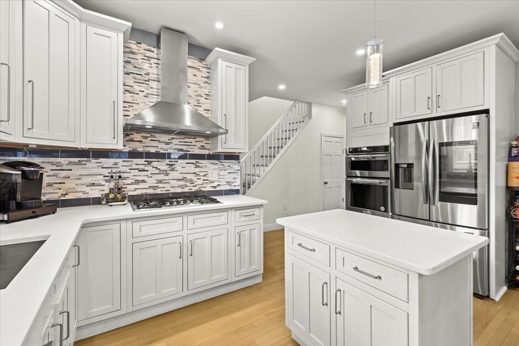 6 Arion Street Boston, MA 02125 - Photo 15 of 42 a kitchen with white cabinets and stainless steel appliances