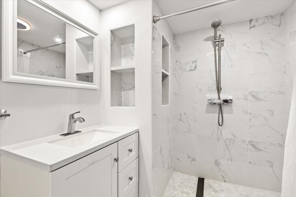 6 Arion Street Boston, MA 02125 - Photo 32 of 42 a bathroom with a shower sink and mirror
