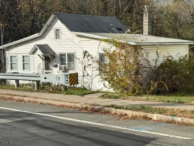 a view of a white house with a yard and potted plants