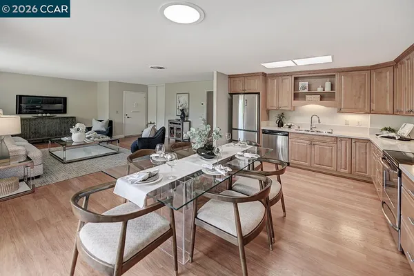 a living room with furniture a flat screen tv and kitchen view