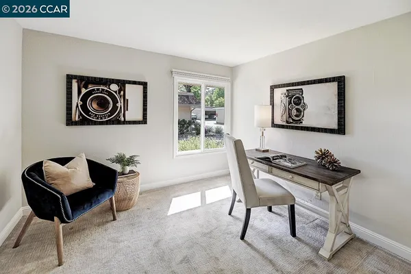 a view of a workspace with furniture and a window