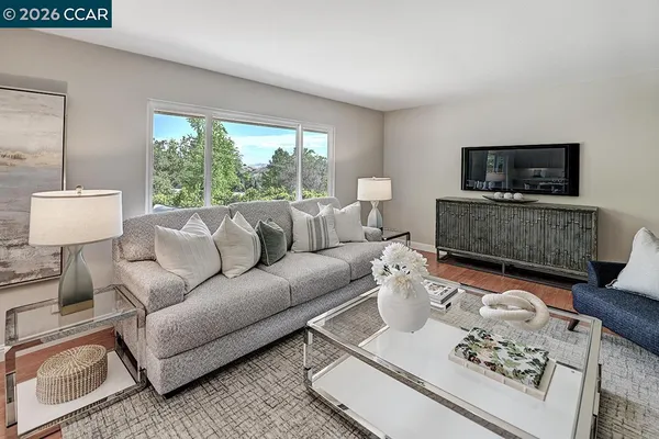 a living room with furniture a flat screen tv and a large window