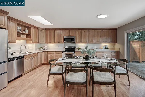 a kitchen with a table chairs microwave and cabinets