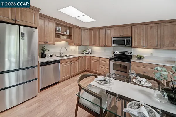 a kitchen with stainless steel appliances a stove a sink a refrigerator and cabinets