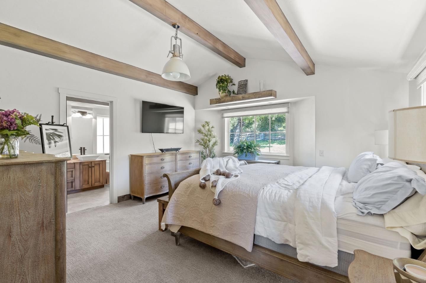 11627 Hidden Hills Road Carmel Valley, CA 93924 - Photo 29 of 62 a bedroom with a large bed and a flat tv screen on dresser