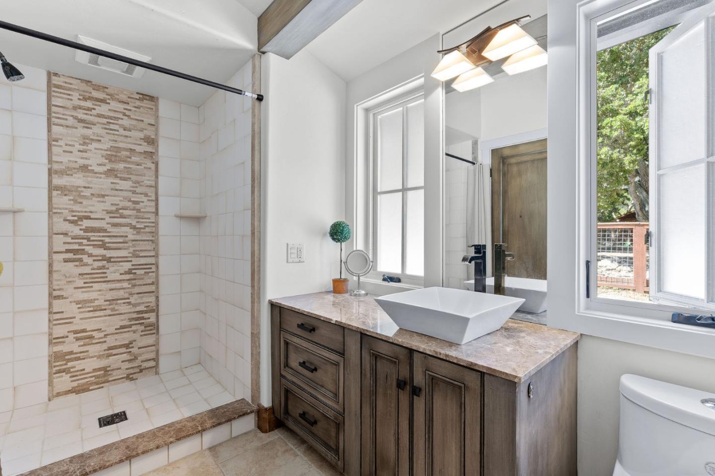 11627 Hidden Hills Road Carmel Valley, CA 93924 - Photo 31 of 62 a bathroom with a granite countertop sink a shower and a mirror