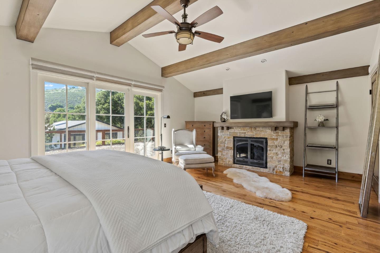 11627 Hidden Hills Road Carmel Valley, CA 93924 - Photo 43 of 62 a spacious bedroom with a balcony a bed and a fireplace