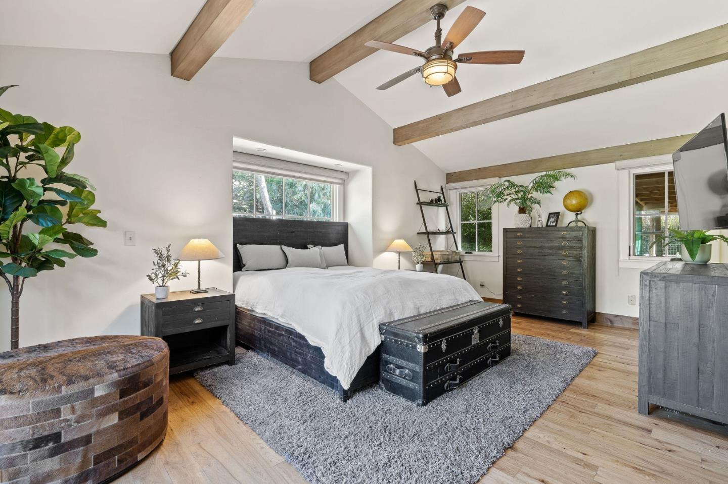 11627 Hidden Hills Road Carmel Valley, CA 93924 - Photo 52 of 62 a spacious bedroom with a bed dresser flowerpot and wooden floor