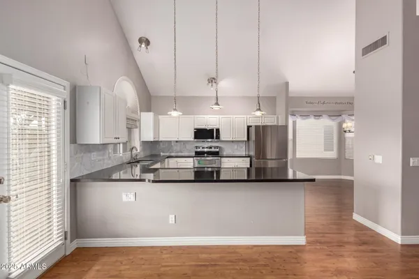 a view of kitchen with stainless steel appliances granite countertop a sink a stove and a refrigerator