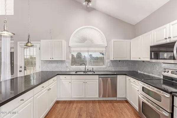 a kitchen with a sink cabinets and window