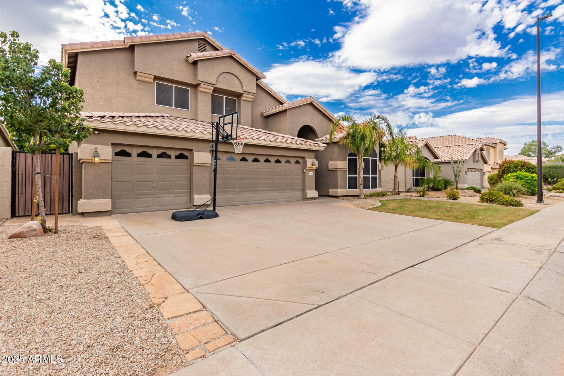 1284 North Conner Avenue Gilbert, AZ 85209 - Photo 2 of 45 a view of a white house with a yard and potted plants