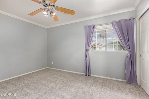 an empty room with a window and a fan