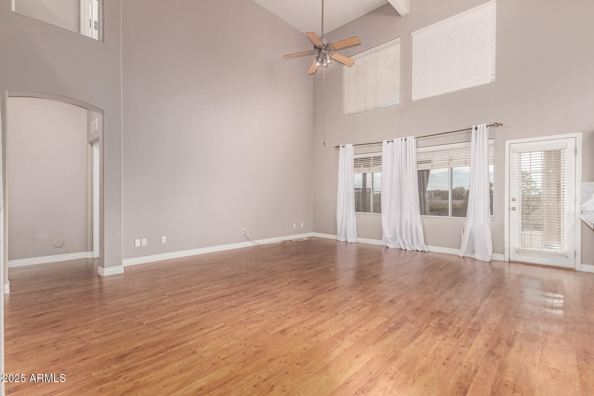 1284 North Conner Avenue Gilbert, AZ 85209 - Photo 8 of 45 a view of an empty room with wooden floor and a window