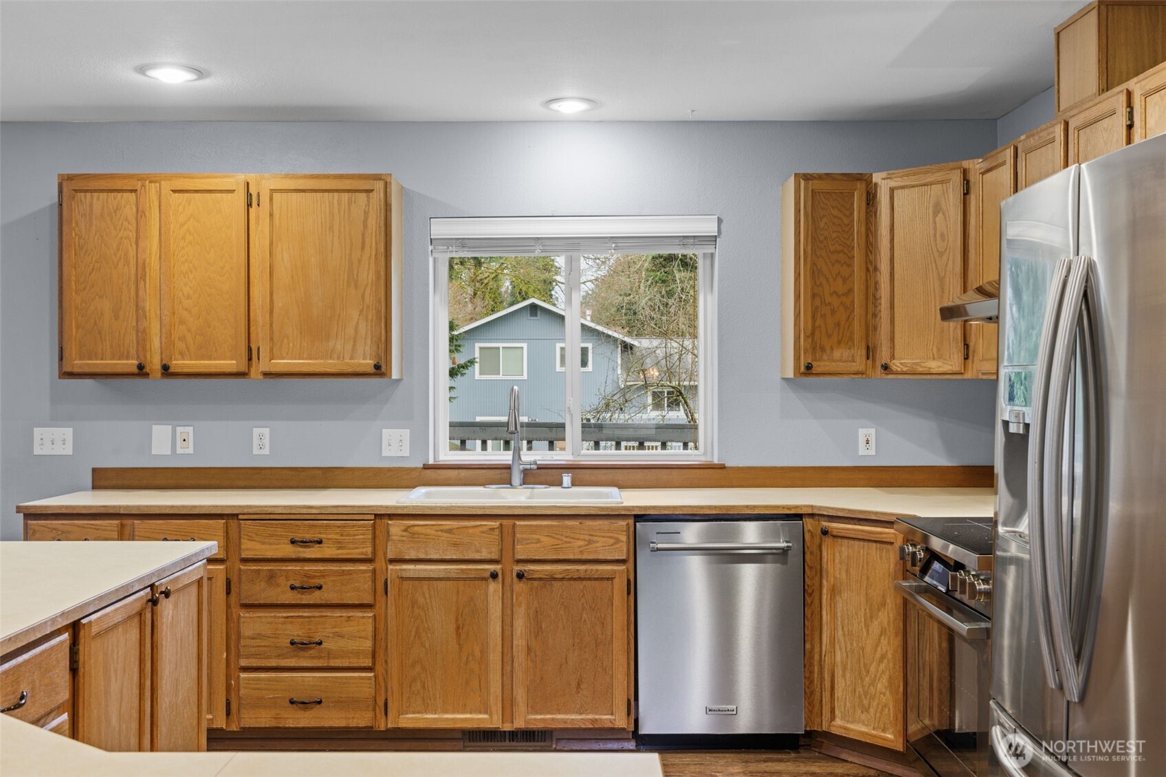 21641 Southeast 266th Street Maple Valley, WA 98038 - Photo 12 of 40 a kitchen with stainless steel appliances granite countertop a sink stove and refrigerator