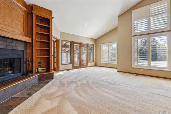 a view of an empty room with a fireplace and a window