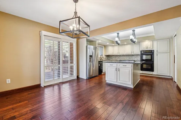 a view of a kitchen with wooden floor a sink and a refrigerator