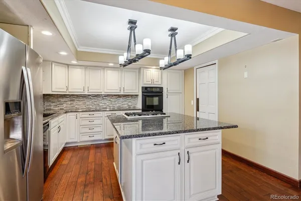 a kitchen with granite countertop a sink stainless steel appliances and wooden floor