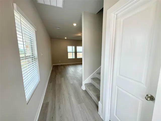 a view of a hallway with wooden floor and staircase