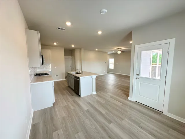 a kitchen with kitchen island a sink a stove a microwave and cabinets