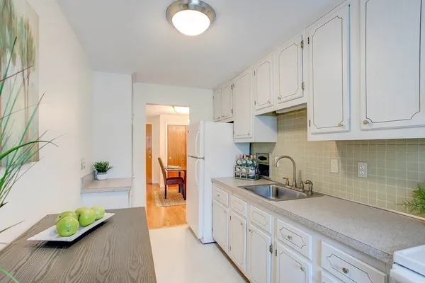 a kitchen with white cabinets and a sink