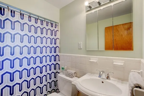 a bathroom with a sink and mirror with toilet