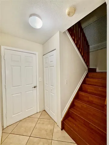a view of a hallway with wooden floor and stairs