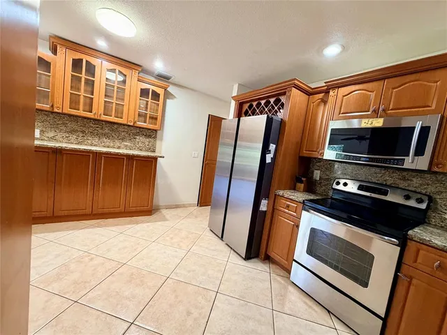 a kitchen with stainless steel appliances granite countertop a refrigerator and a stove