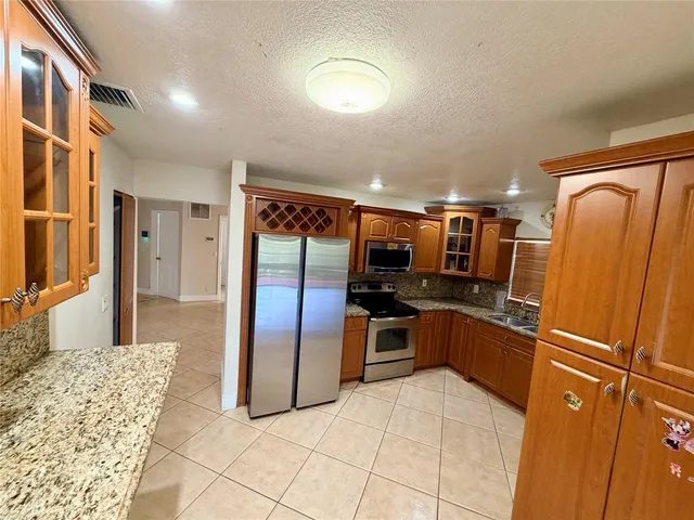 a kitchen with stainless steel appliances granite countertop a refrigerator and a sink