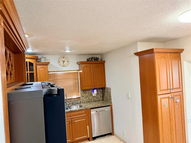 a kitchen with stainless steel appliances granite countertop a refrigerator a sink and a stove