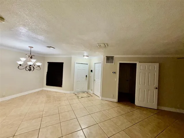 a view of an empty room with wooden floor and a ceiling fan
