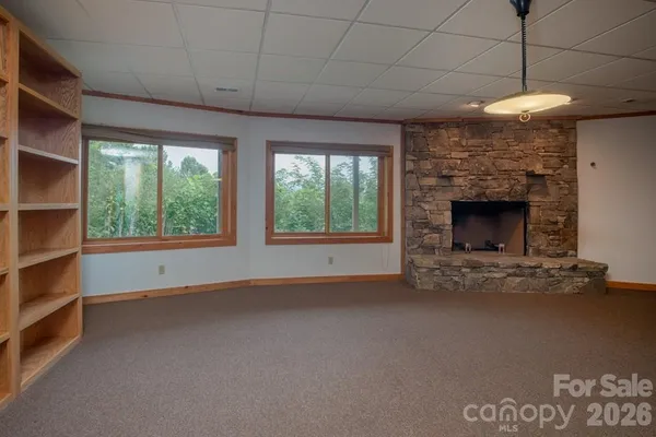 a view of empty room with fireplace and windows