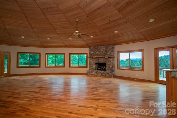 a view of empty room with wooden floor and fireplace