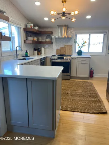 a kitchen with kitchen island a sink stainless steel appliances and cabinets