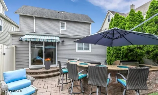 a view of a patio with table and chairs under an umbrella