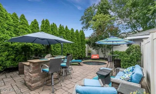 a view of patio with furniture and a table and chairs under an umbrella