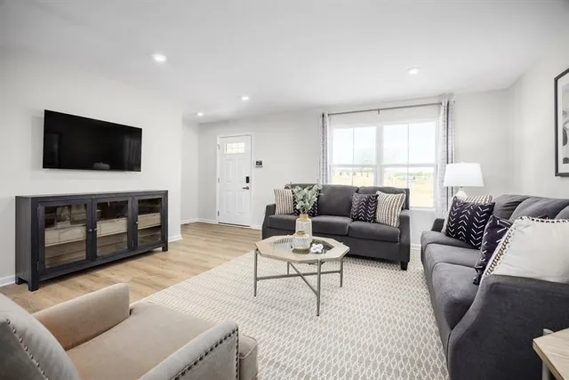 a living room with furniture a fireplace and a flat screen tv