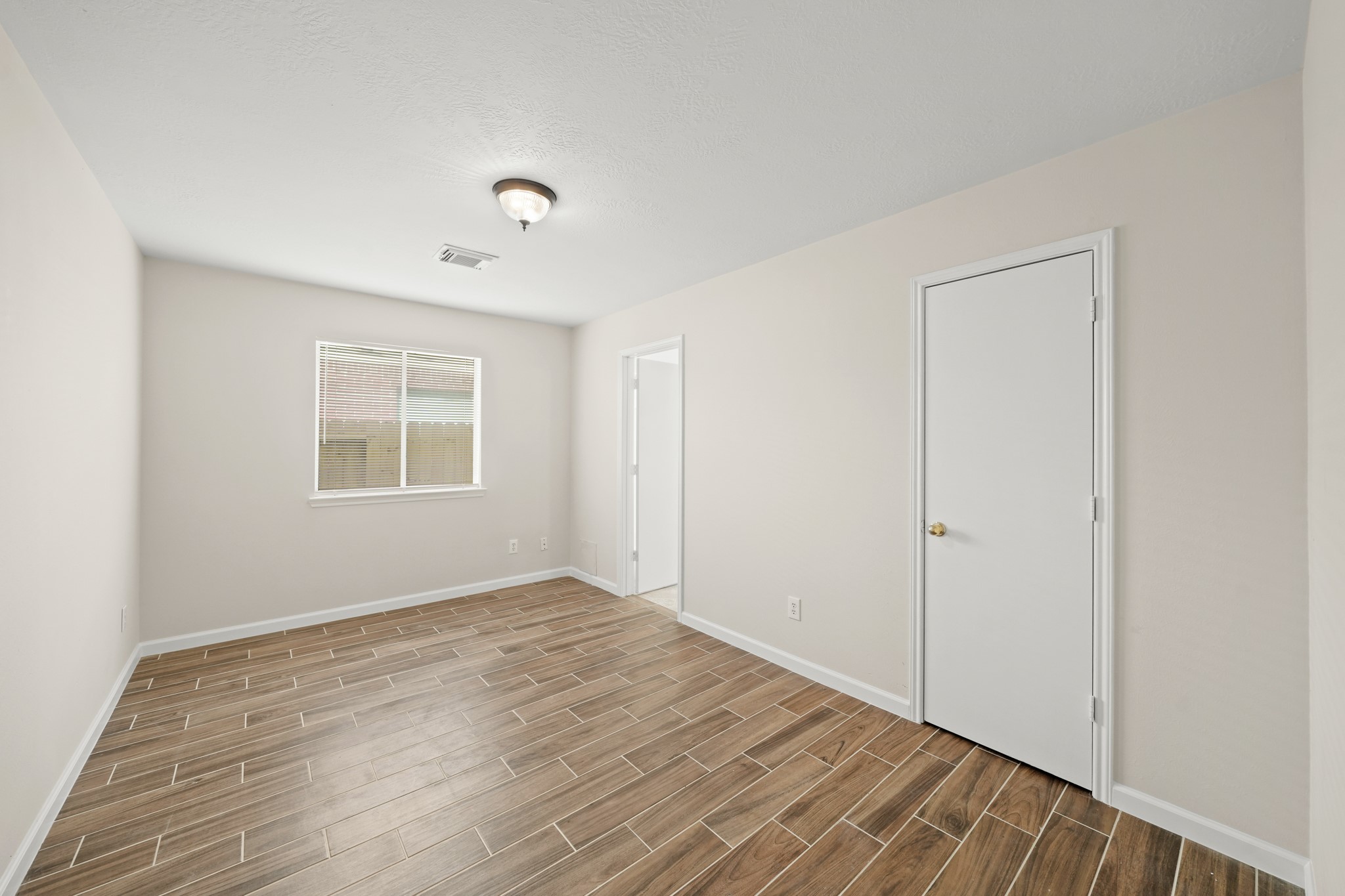1426 Cartwright Road Missouri City, TX 77489 - Photo 13 of 26 an empty room with wooden floor and windows