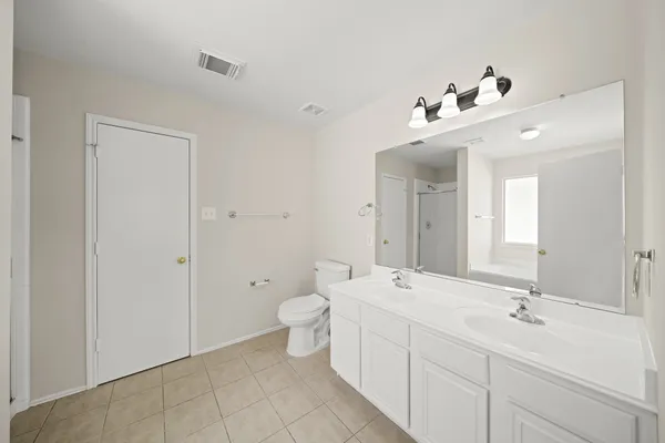 a bathroom with a double vanity sink mirror and toilet