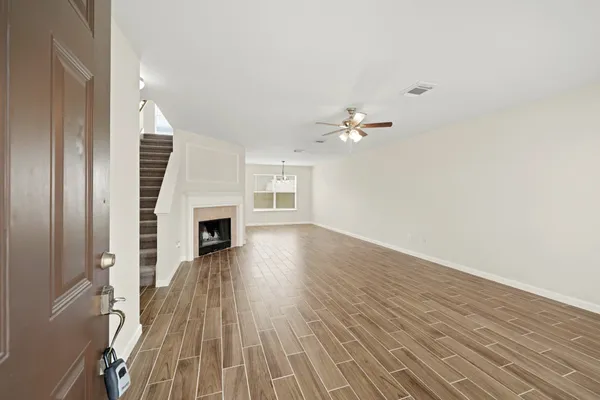 a view of a livingroom with wooden floor and a fireplace