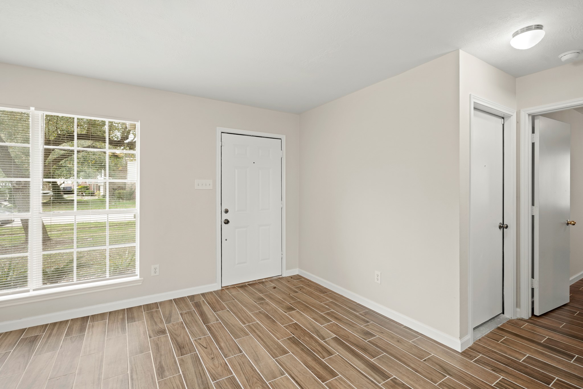 1426 Cartwright Road Missouri City, TX 77489 - Photo 4 of 26 an empty room with wooden floor and windows