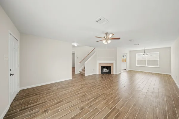 a view of empty room with wooden floor and fireplace