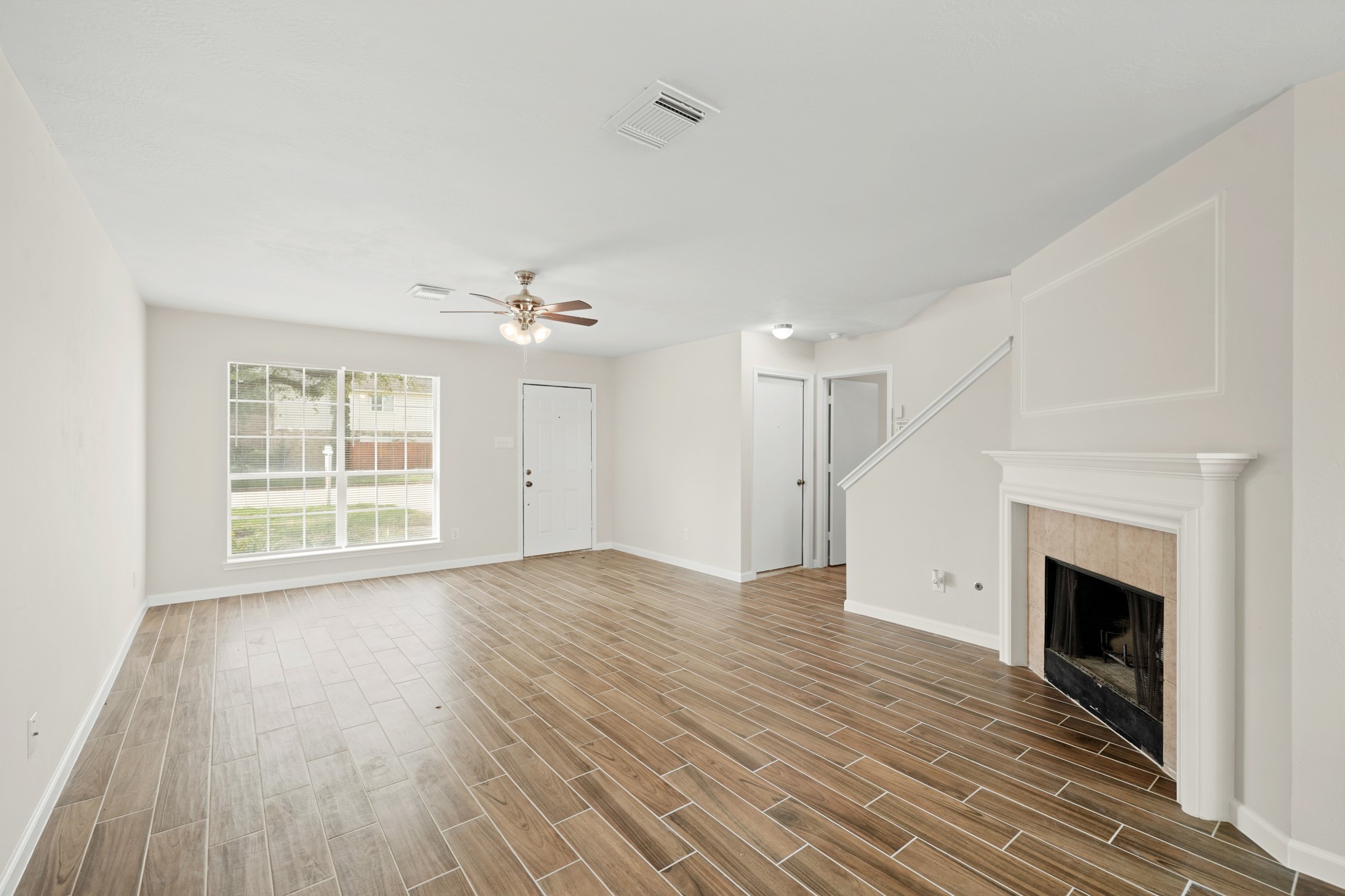 1426 Cartwright Road Missouri City, TX 77489 - Photo 6 of 26 a view of empty room with wooden floor and fireplace