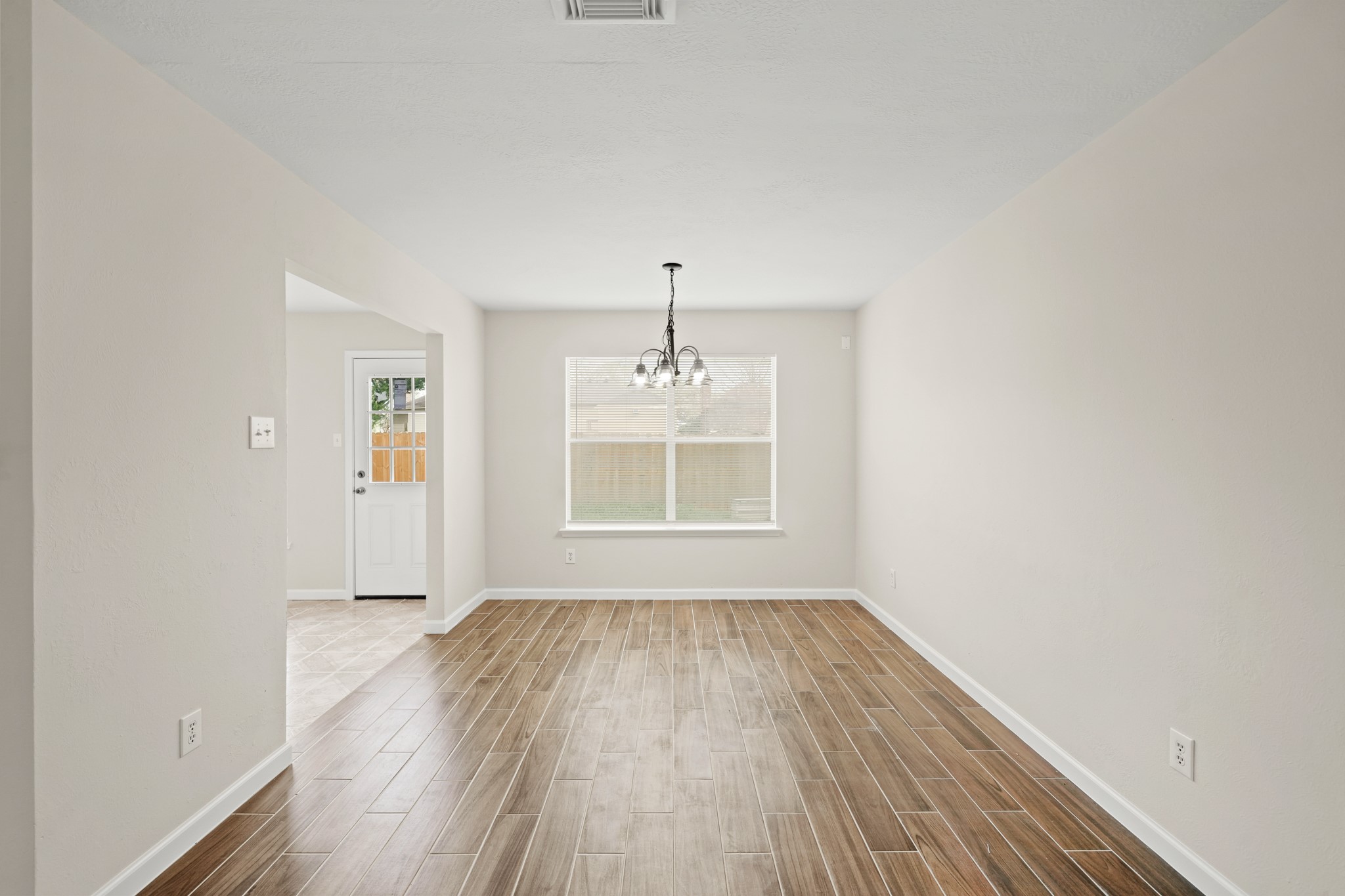 1426 Cartwright Road Missouri City, TX 77489 - Photo 7 of 26 a view of an empty room with wooden floor and a window
