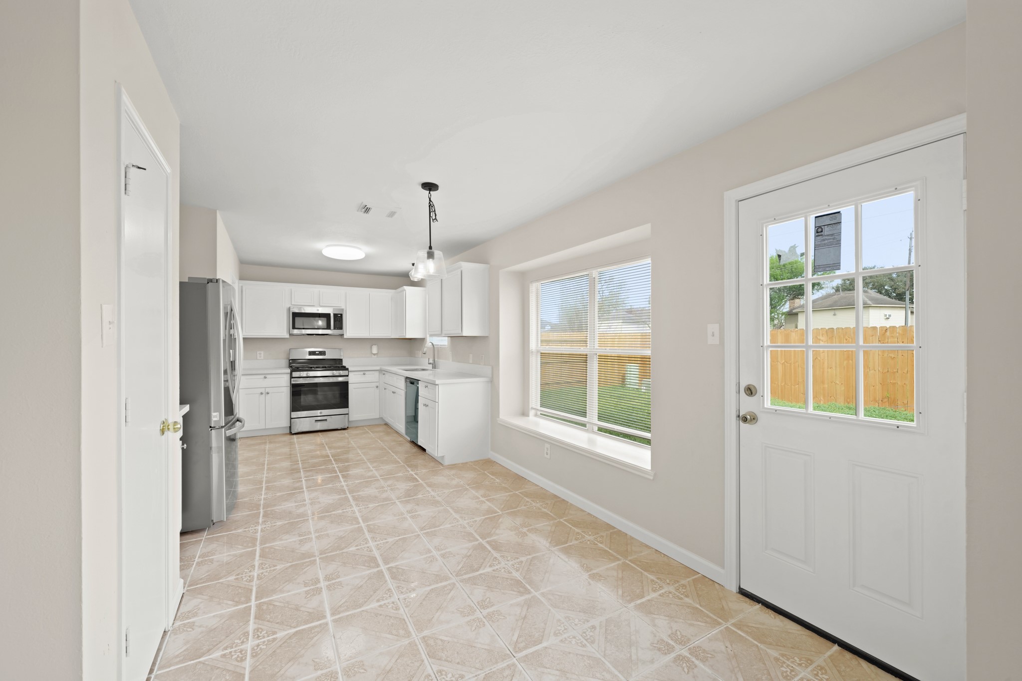1426 Cartwright Road Missouri City, TX 77489 - Photo 8 of 26 a large white kitchen with window and refrigerator