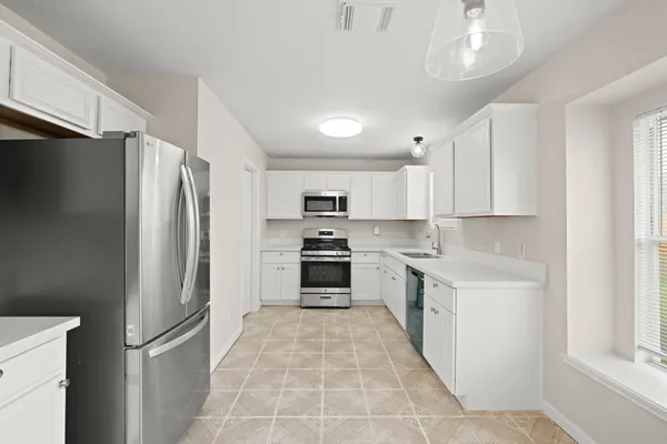 a large kitchen with cabinets and stainless steel appliances